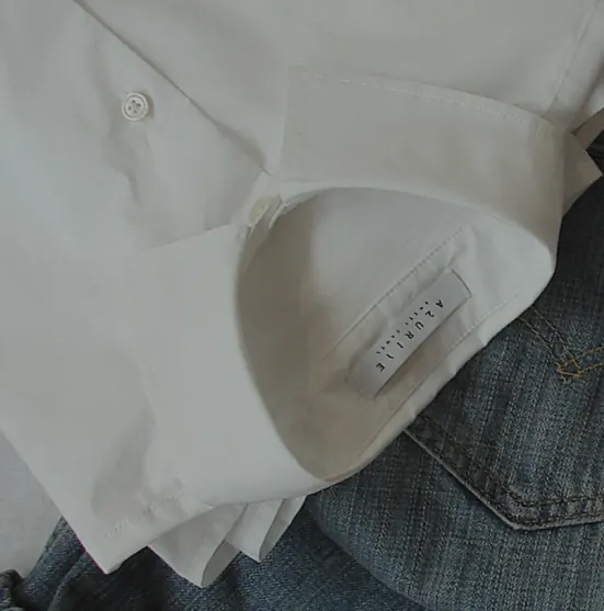 Camisa blanca doblada sobre unos vaqueros